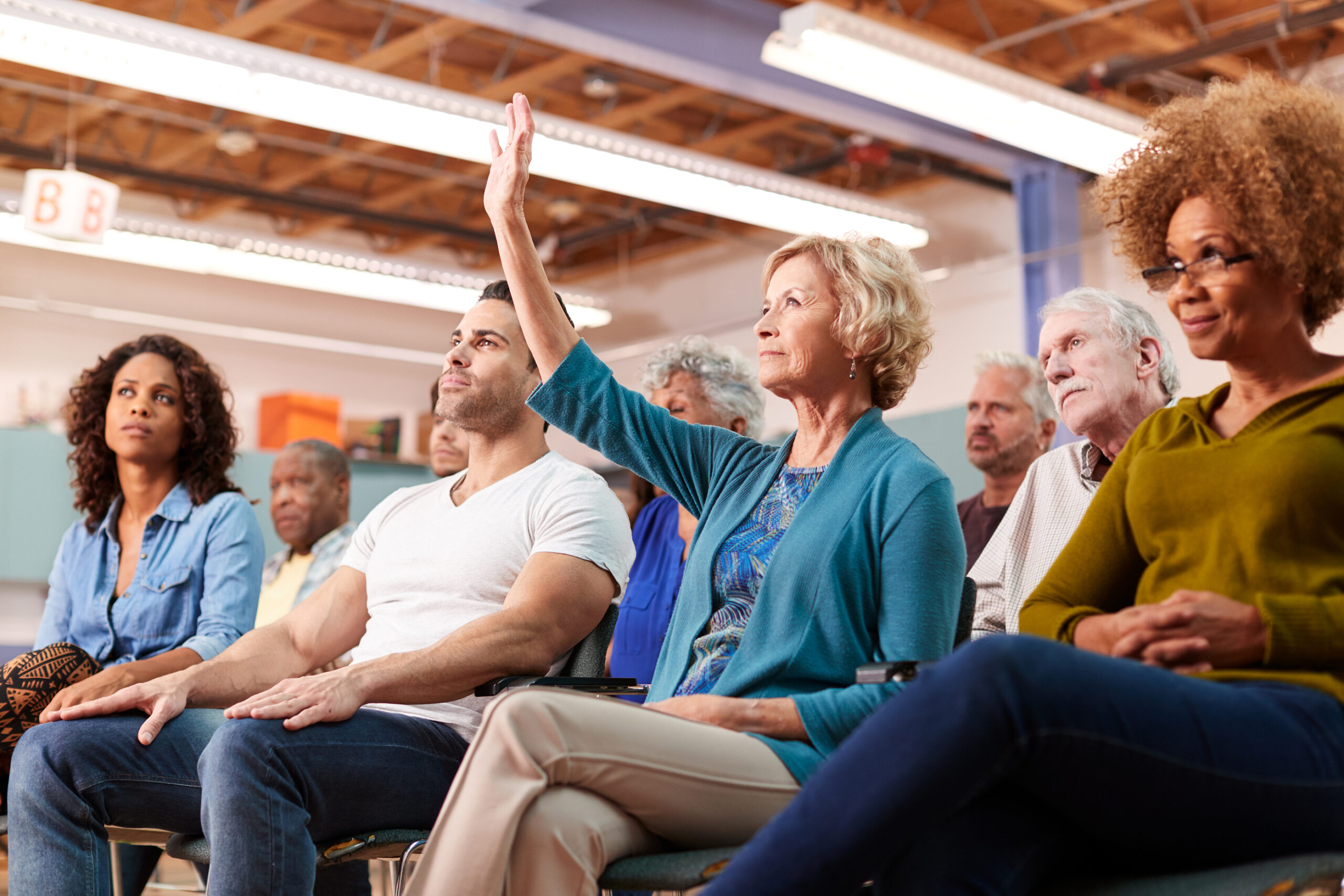 Woman Asking Question At Neighborhood Meeting In Community Cente Course listing